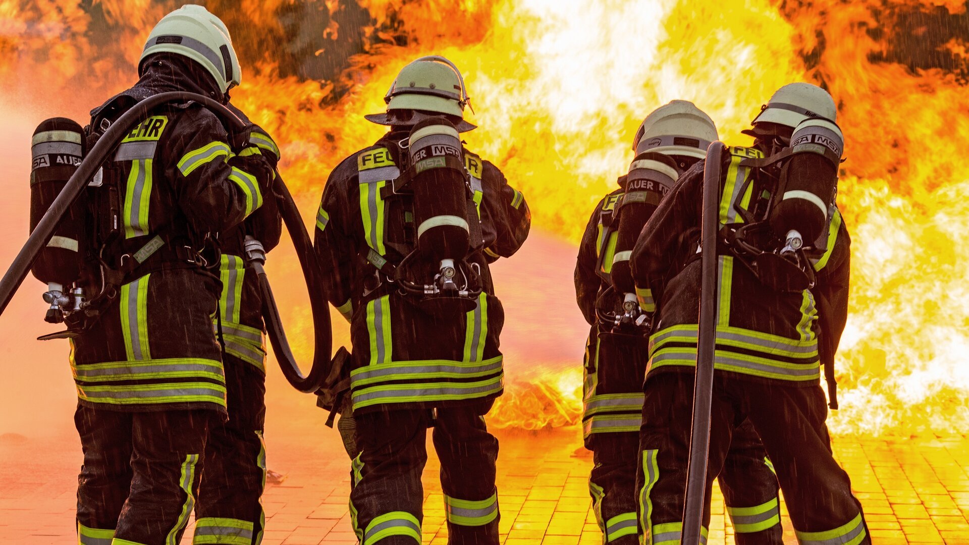 Vier Feuerwehrleute bekämpfen einen Brand